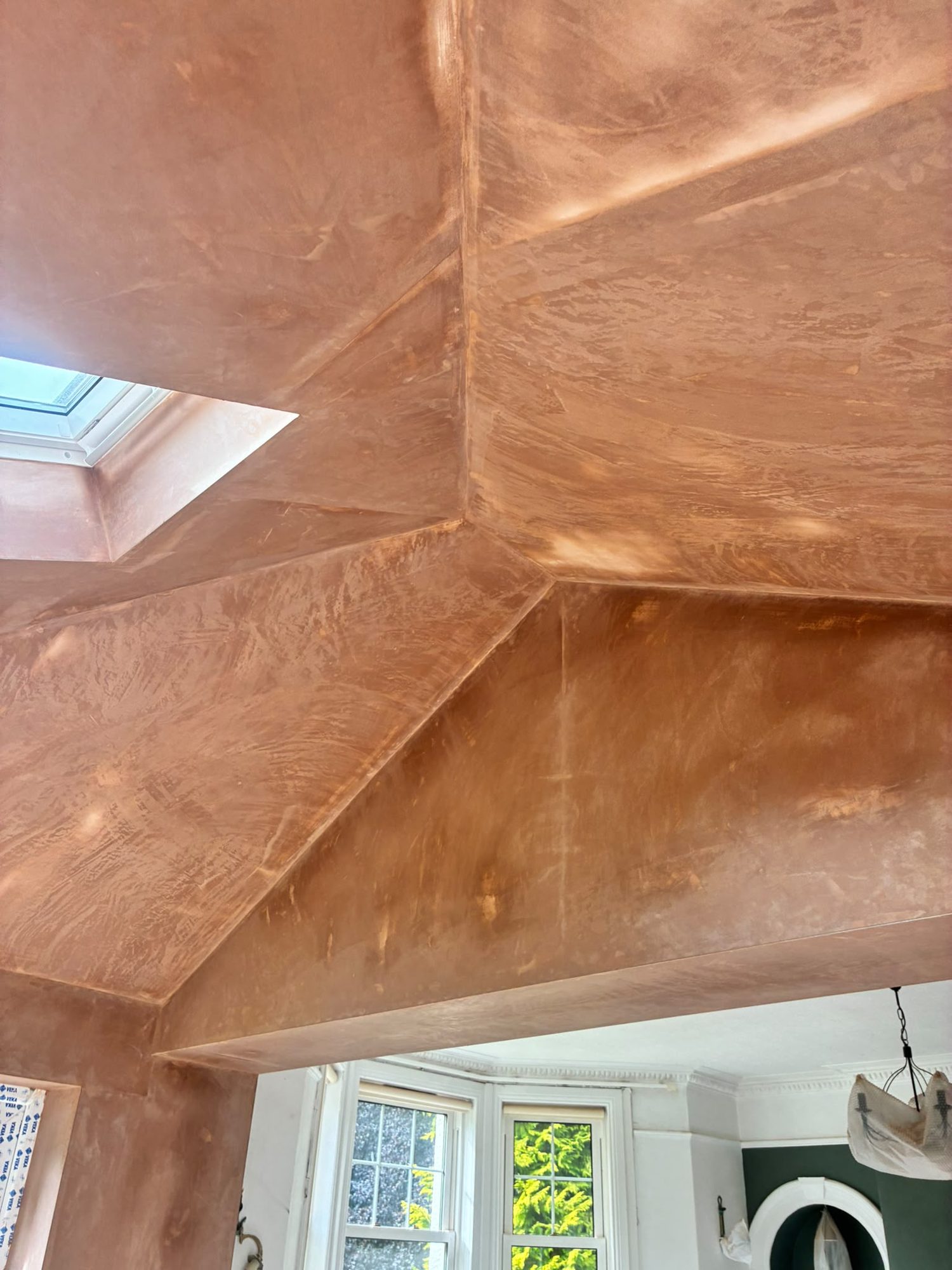 Freshly plastered vaulted ceiling with rooflight inside a house extension