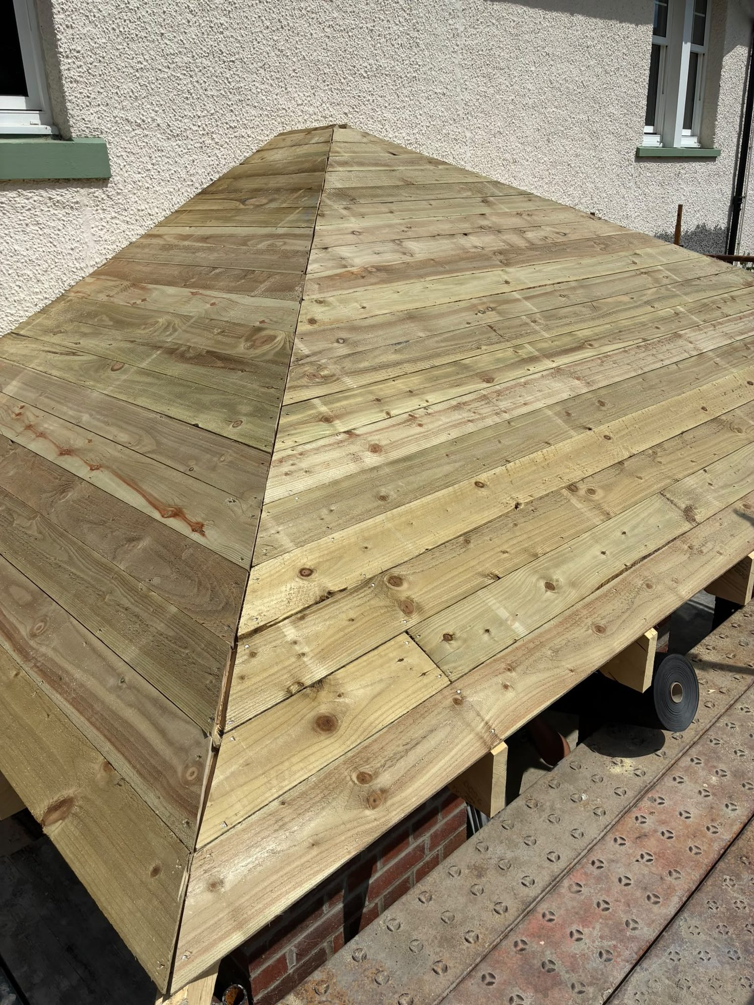Timber sarking boards fitted to a hipped roof before slating