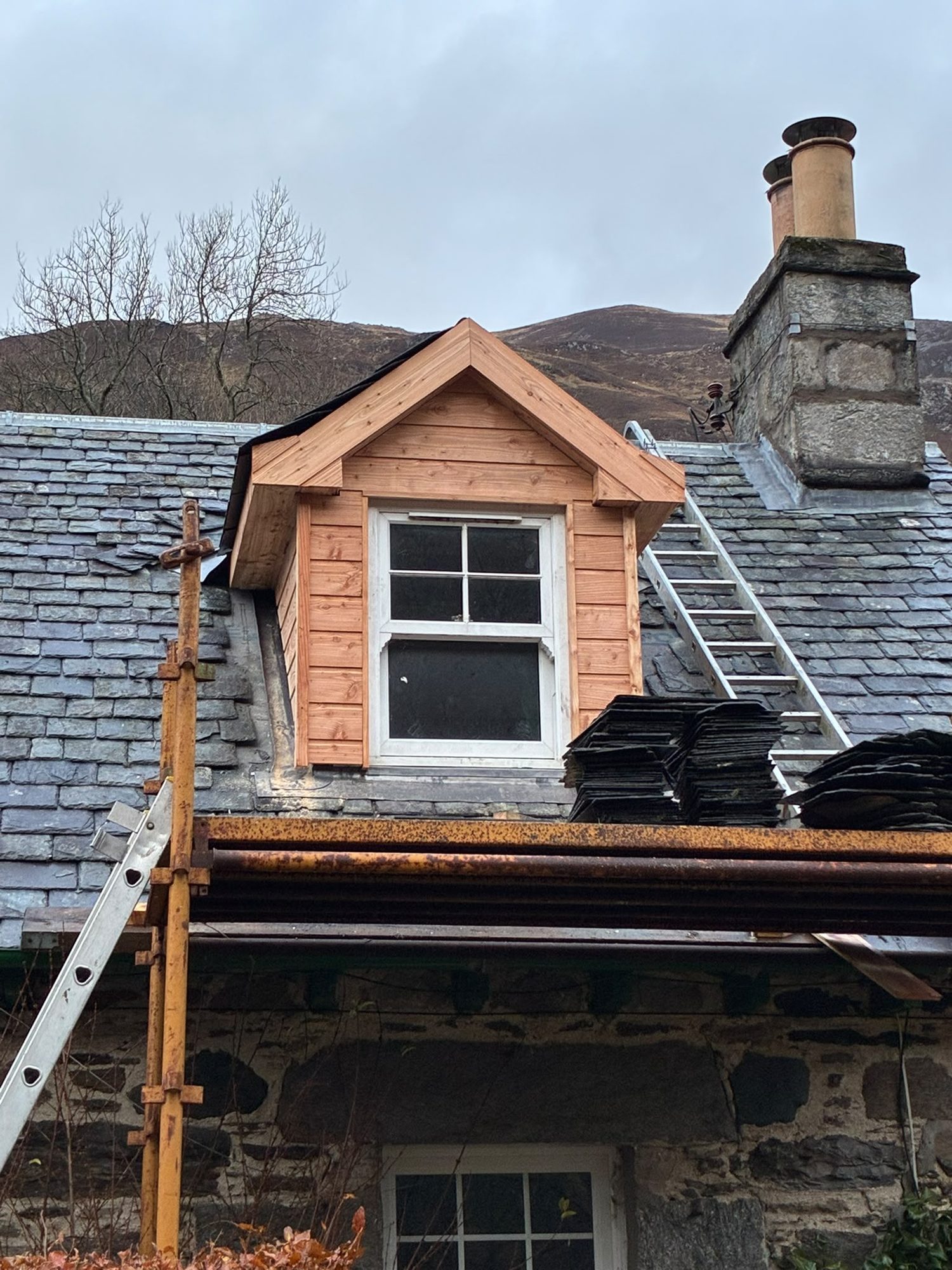 New dormer window joinery and slate roofing on a stone cottage