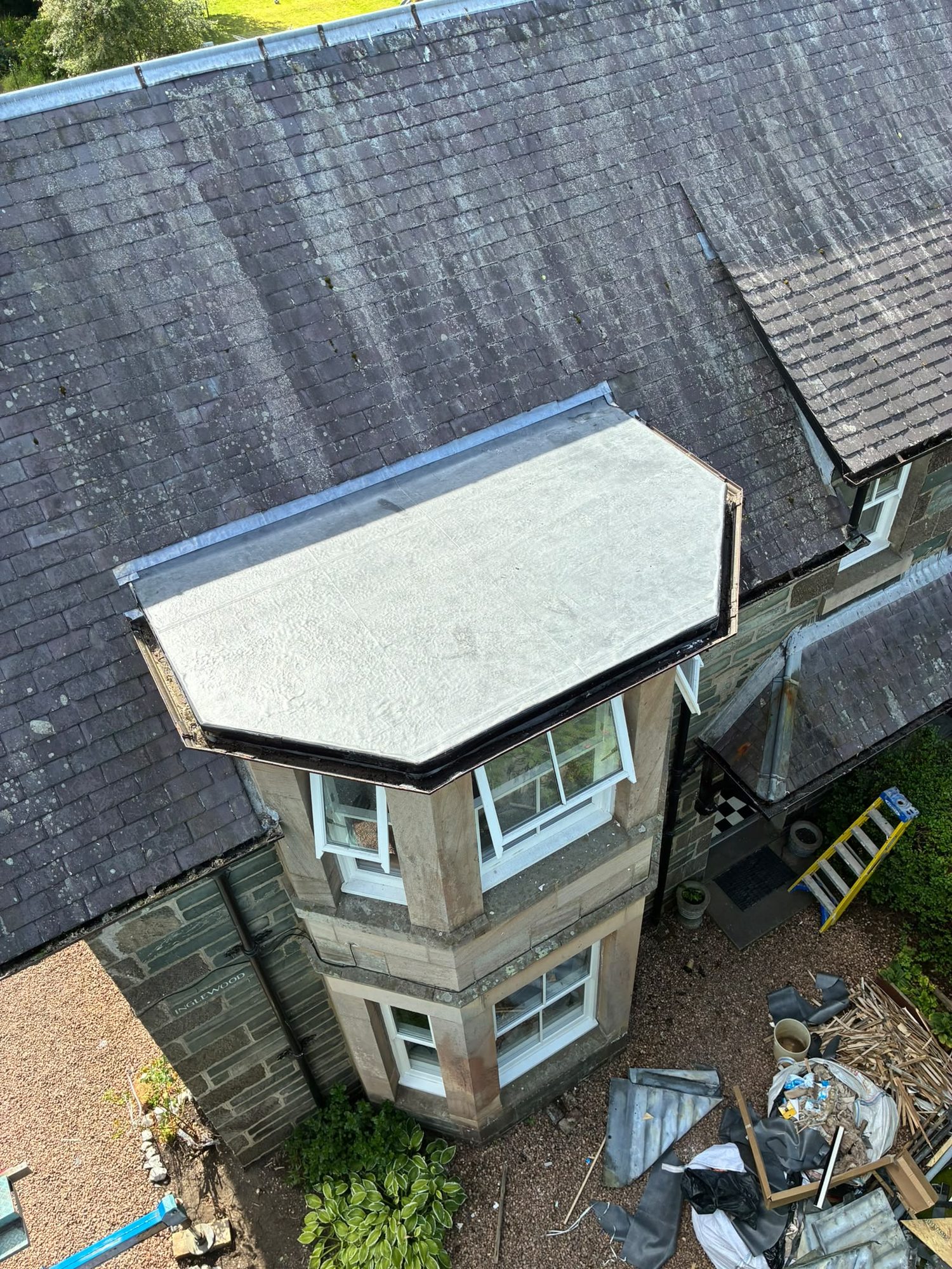 Completed flat roof repair over a stone bay window