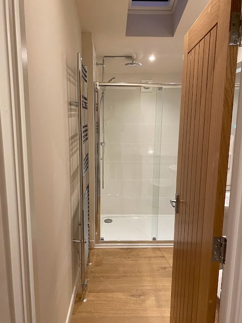 Finished shower room with glass enclosure and heated towel rail