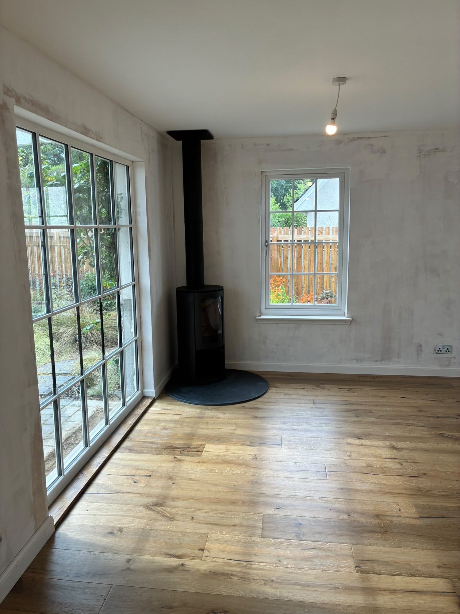 Renovated living room with wood burner and large glazed doors
