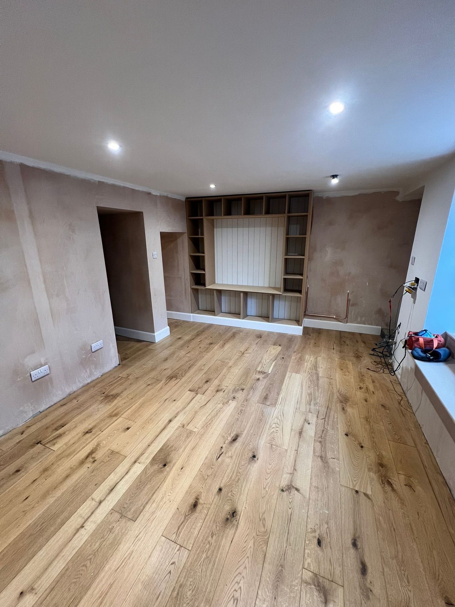 Built-in bookcase and second fix joinery in a renovated room with oak floor