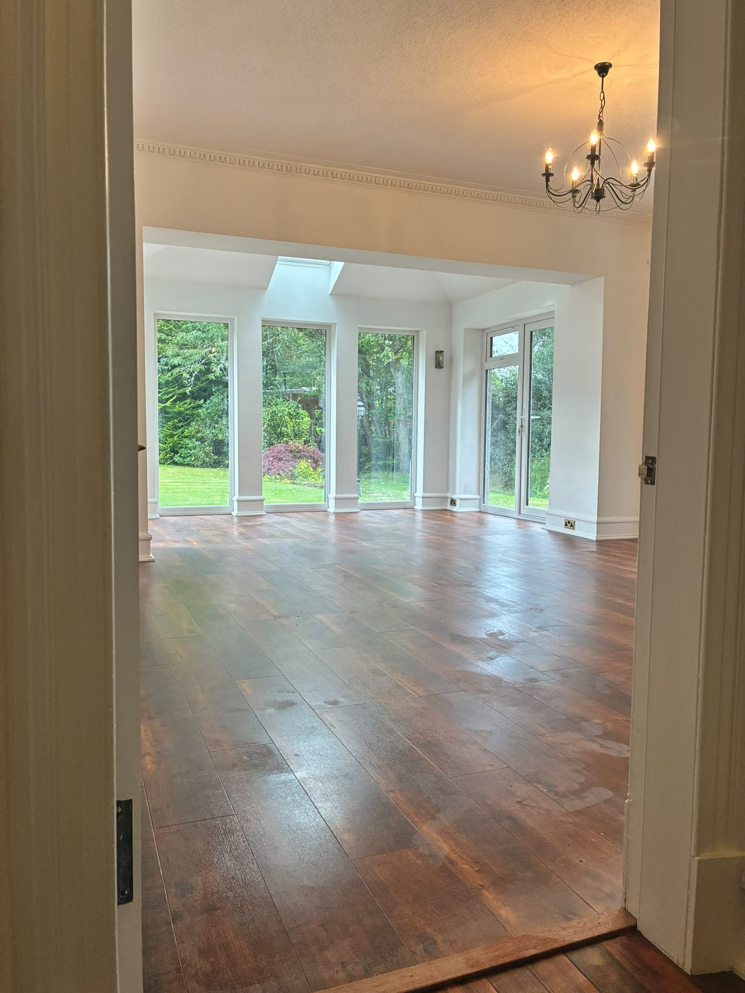 Completed house extension interior with hardwood floor and garden views