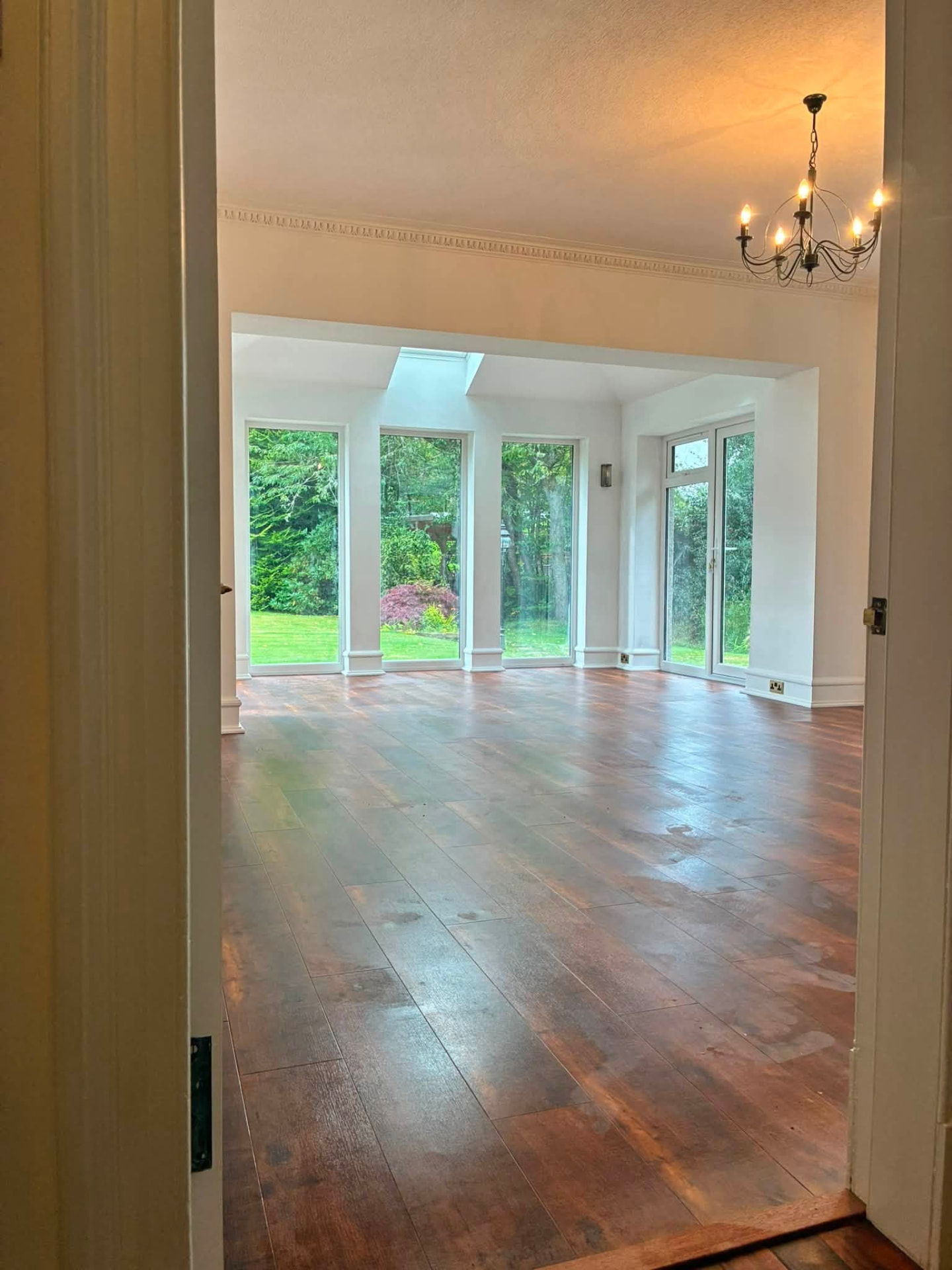 Finished glazed extension interior with timber flooring and garden views