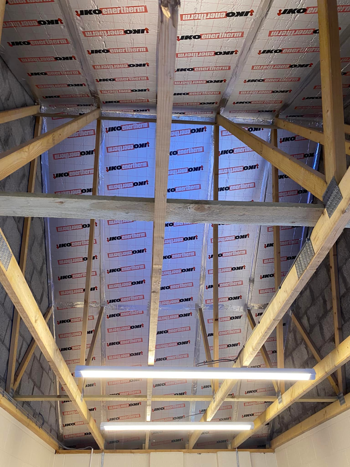 Exposed timber roof framing and insulation during construction