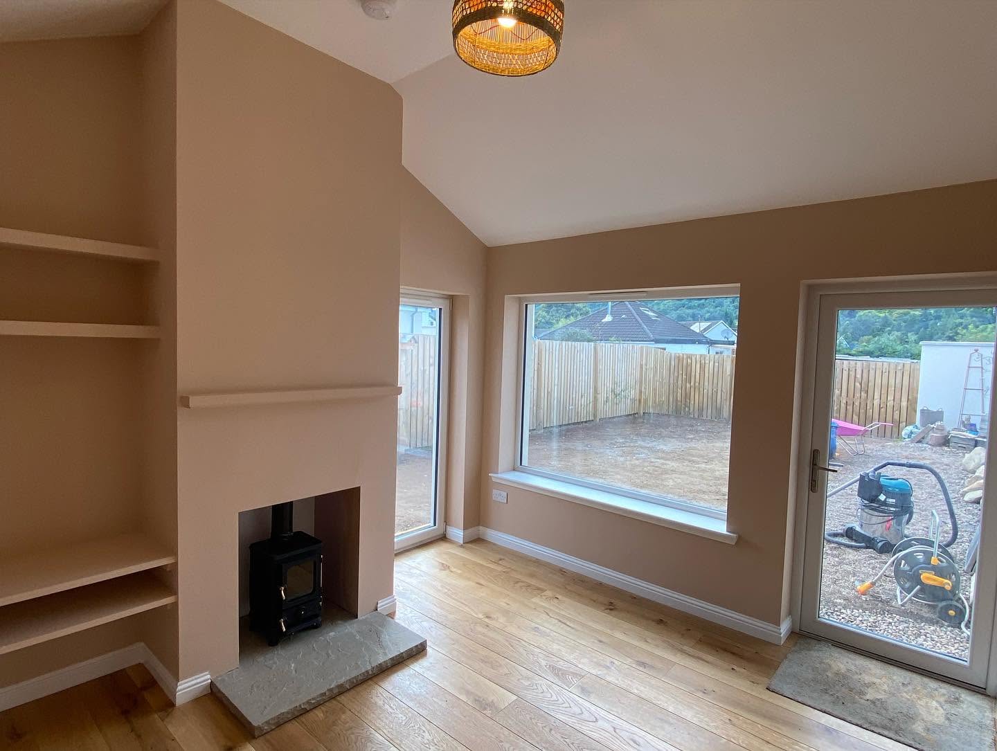 Finished room with timber flooring, fireplace and glazed garden doors