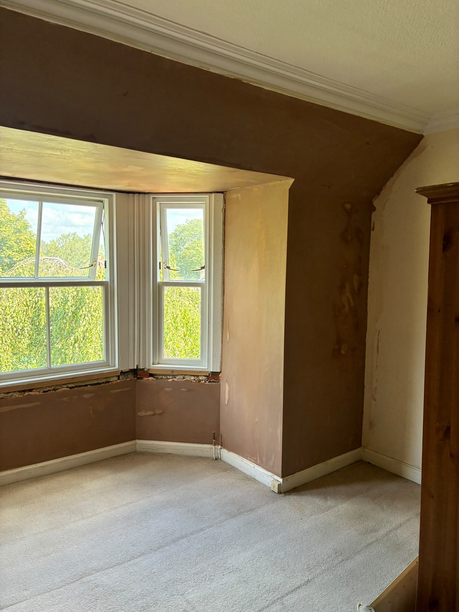 Bedroom renovation with fresh replastering around a bay window