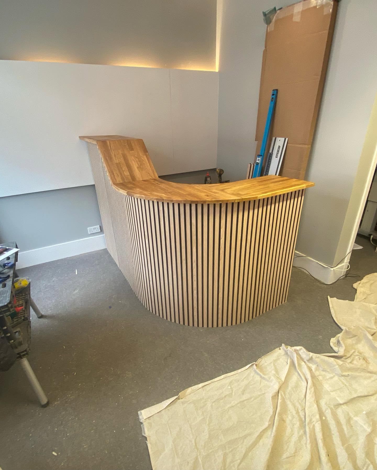 Completed curved timber-slatted reception desk